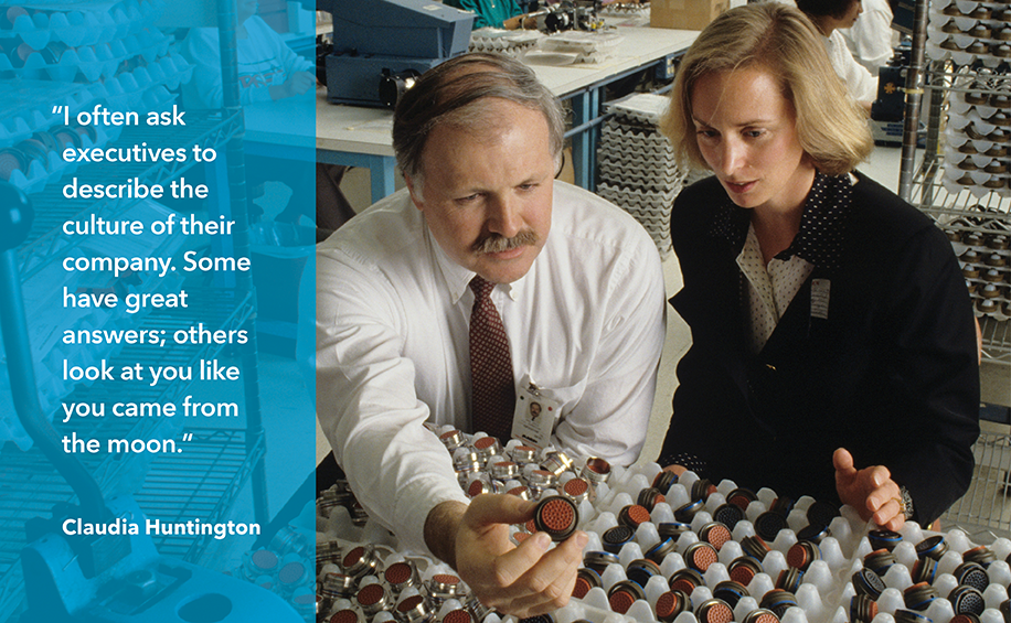 Photo depicts Claudia Huntington speaking with a company representative on a research visit to Matrix Science Corporation in Torrance, California, circa 1990. Pull-quote at left reads: “I often ask executives to describe the culture of their company. Some have great answers; others look at you like you came from the moon.” Claudia Huntington.