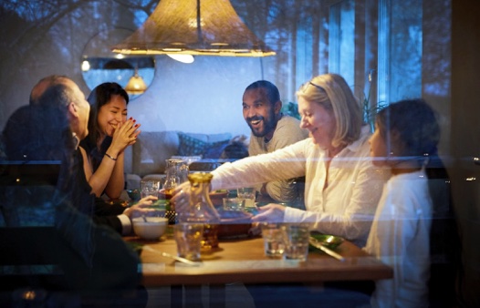 Family sharing diner and laughing.