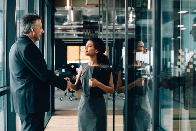 Woman and man shaking hands in an office