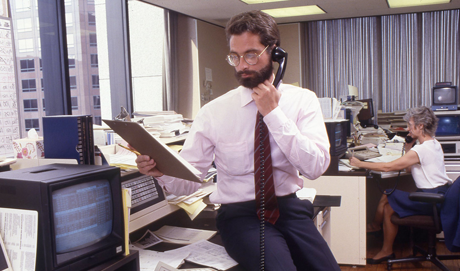 John Smet in an office environment on the telephone holding a clipboard circa 1986