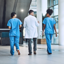 Médico y enfermeras caminando por un hospital