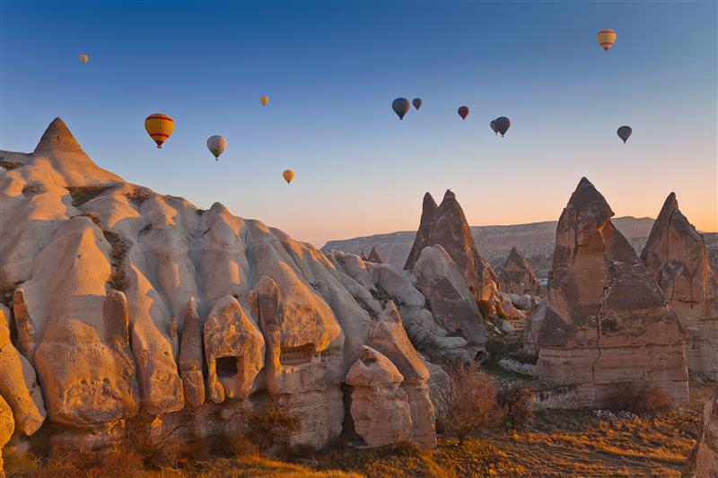 hot air balloons flying over rock mountains